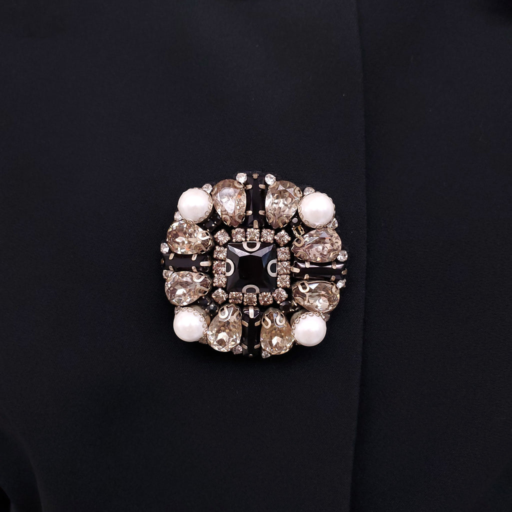 ANDREW GN BLACK SKIRT SUIT WITH FLORAL EYELET COLLAR AND CRYSTAL EMBLEM DETAILS - SIZE 46