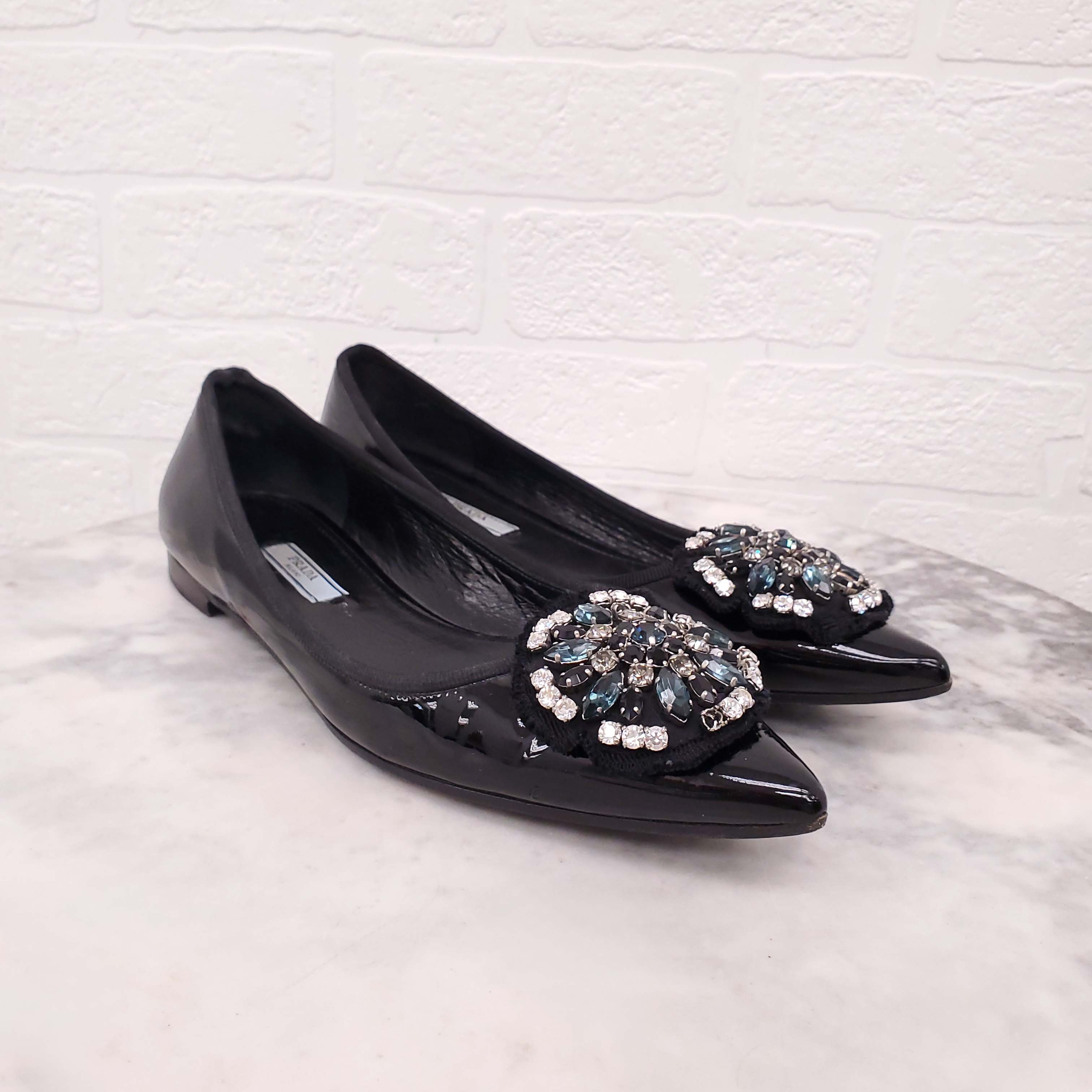 PRADA BLACK PATENT FLATS WITH CRYSTAL EMBLEM - SIZE 38.5